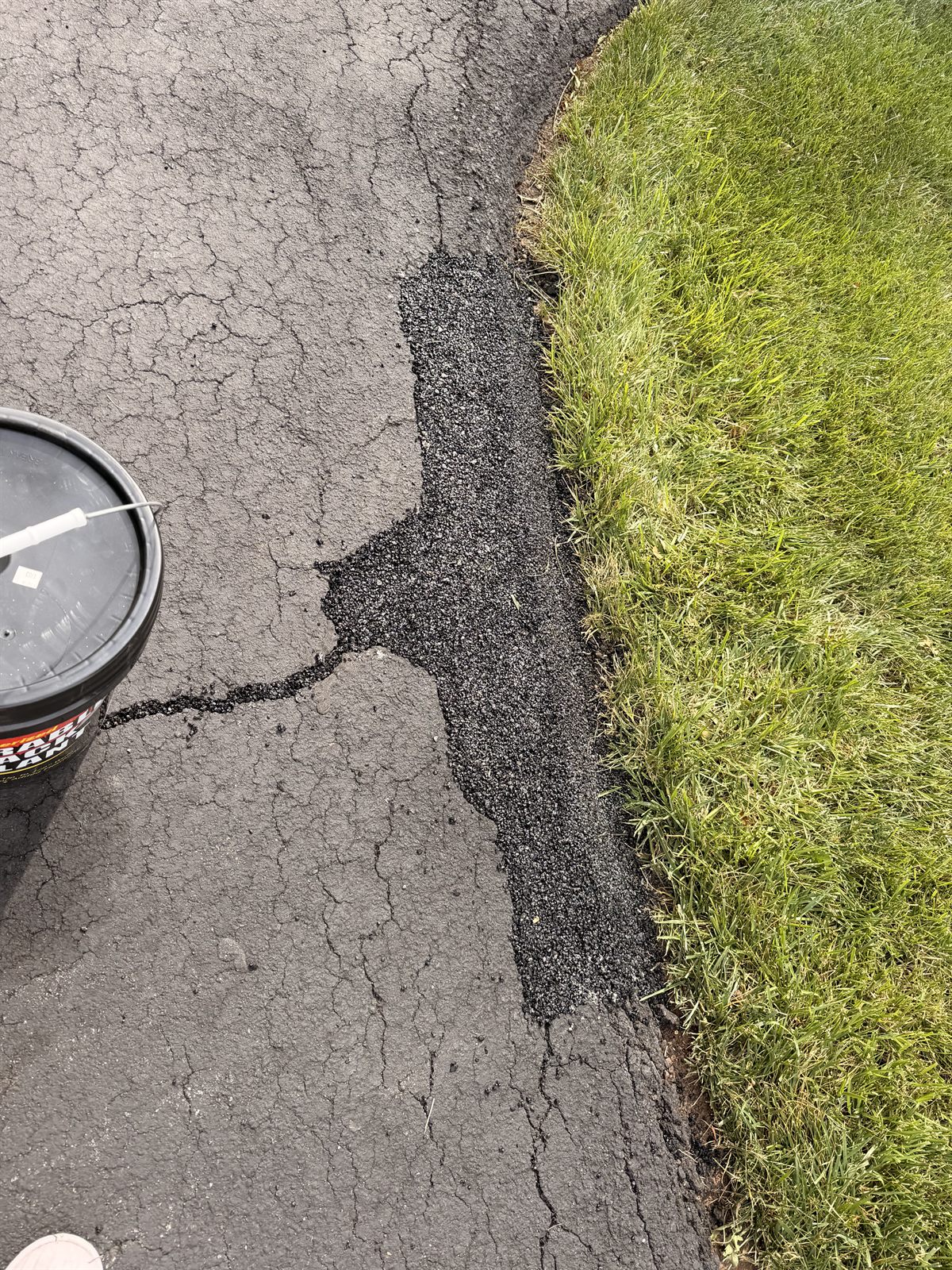 Asphalt edge repair and crack filling along a parking lot edge to stop water intrusion